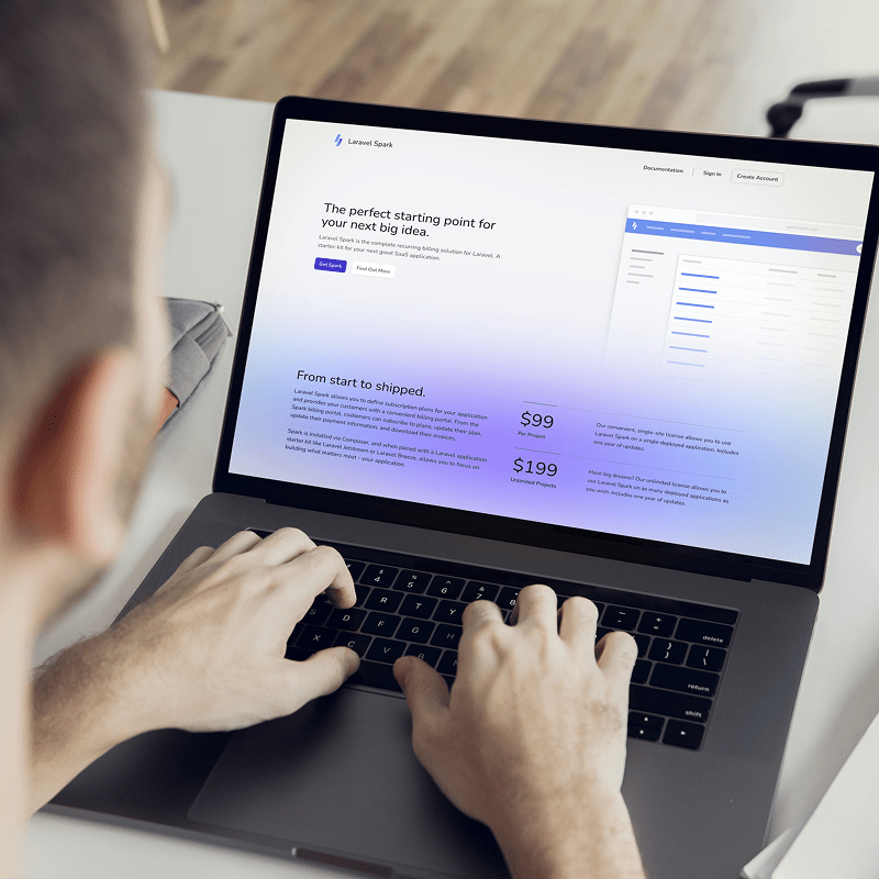 Person arbeitet am Laptop mit ge&ouml;ffneter Laravel Spark Webseite