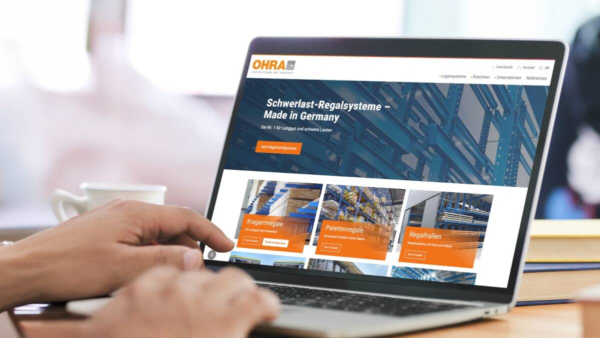 Eine Person bedient ein Laptop, auf dessen Bildschirm die OHRA-Startseite mit Schwerlast-Regalsystemen zu sehen ist.
